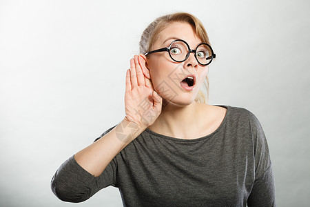 谣言流言蜚语的新闻贩子女孩倾听手势震惊,惊讶,八卦的女人流言蜚语流言蜚语震惊了女孩的肖像图片