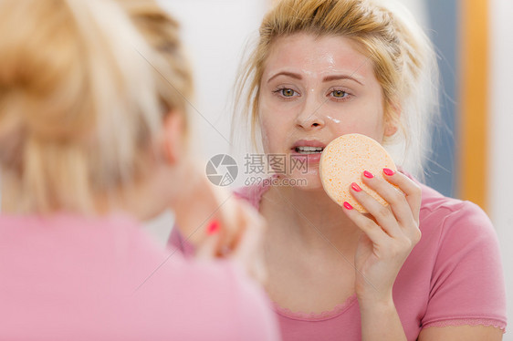 肤色,护肤品的女人脸上洗胶,着海绵来清洁她的皮肤女人脸上洗胶,着海绵图片