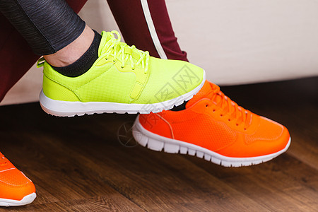 两个目全非的女人穿着运动鞋,红色霓虹灯绿色的运动装件两双运动鞋图片
