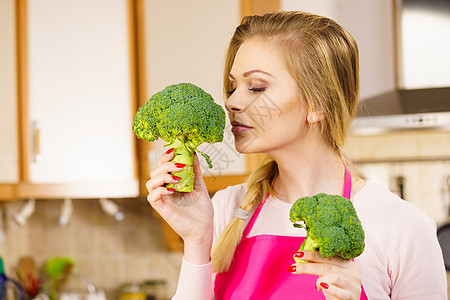 快乐的轻女人着生绿色蔬菜西兰花天然机健康食品妇女持西兰花蔬菜图片