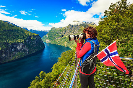 旅游假日图片旅游奥恩斯文根鹰路角度欣赏峡湾景观的女游客,用相机拍照,挪威游客拍摄峡湾景观,挪威背景图片
