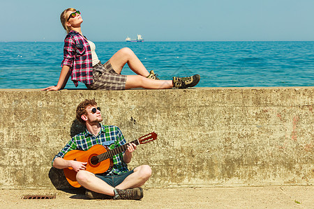 轻人海边约会的时候,户外给女朋友弹吉他图片