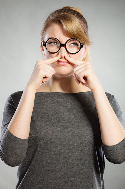用手指捏她的鼻子,因为气味恶臭,令人快的臭味部反应女孩因恶臭而捏