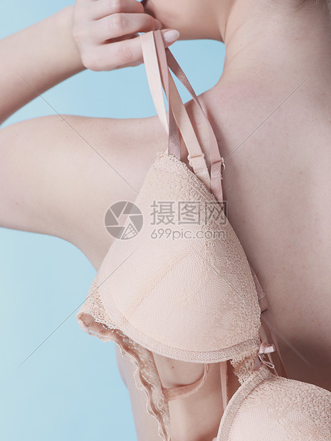 胸怀的苗条迷人的女人手里着米色的跳水胸罩蓝色的女人手里着米色胸罩