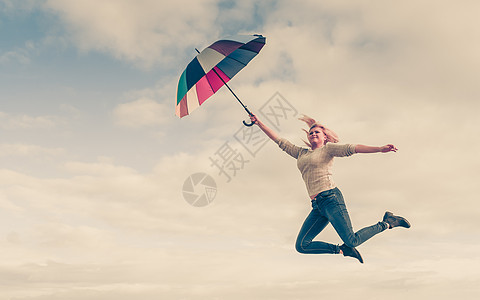 快乐,享受天气,感觉很棒的女人用五颜六色的伞跳进清澈的蓝天女人海滩上着五颜六色的雨伞跳跃图片