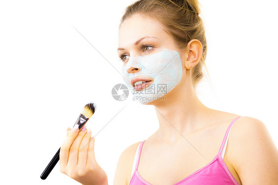轻的女人用刷子绿泥具,白色少女照顾油皮肤,净化毛孔美容治疗护肤女孩用绿色泥浆具图片