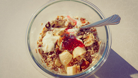 健康早餐燕麦粥,酸奶,香蕉水果葵花籽碗里,阳光明媚的早晨健康早餐燕麦片水果背景图片