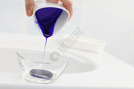女人把紫色的染发剂倒进透明的碗里图片
