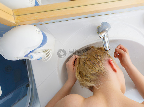 女人浴室水槽里洗她长长的金发护发观念女人水槽里洗头发图片