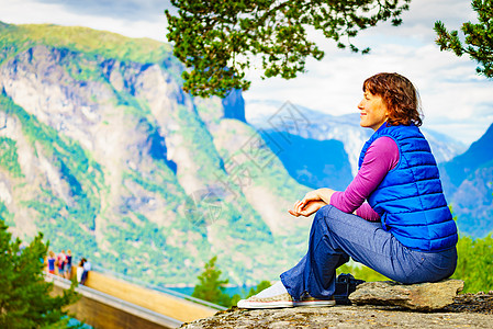 游客妇女越过stestein了望台,看着挪威峡湾山脉的景色徒步旅行,旅途