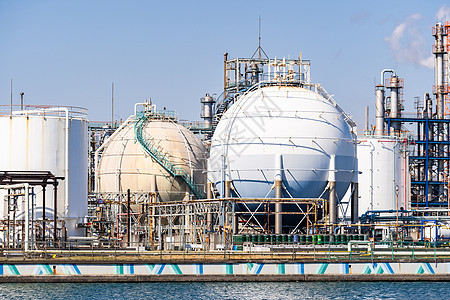 位于日本东京附近的川崎市的化工厂,拥气体储存管道结构,烟气来自烟囱背景图片