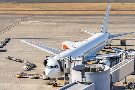 机场喷气桥白色飞机卸货装载乘客图片