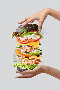 自制美味的三明治,由飞行配料虾,新鲜机蔬菜黑色包个女人的手浅灰色背景与飞行汉堡与新鲜的成分的女人的手图片
