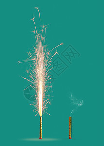 燃烧烟花与明亮的火花烟雾燃烧的蜡烛绿松石背景,节日活动的两个烟花燃烧燃烧绿松石的背景图片