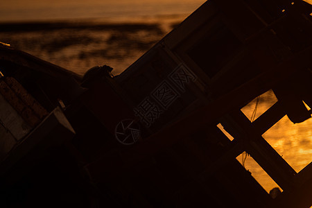 日落时海边的旧渔船图片