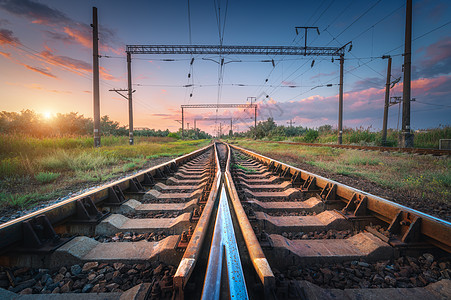火车站日落时美丽的天空夏季农村工业景观与铁路,蓝天与五颜六色的云彩阳光,绿色的草铁路站台运输重工业图片