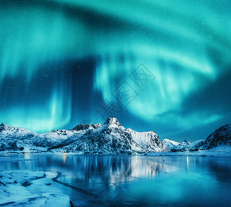 北极光雪山上,冰冻的海岸挪威洛福滕岛的水中的反射北极光冬季景观与极地灯,冰水中天空星星极光雪山上方的北图片