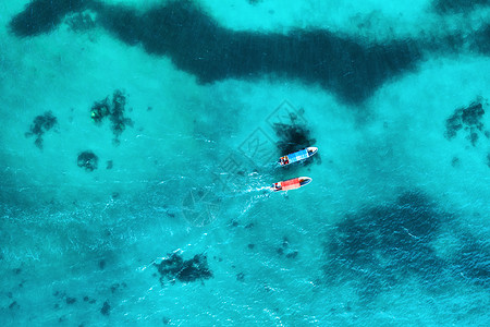 夏天日落时,透明的蓝色水中俯瞰渔船非洲桑给巴尔印度洋漂浮船的无人驾驶飞机上俯瞰景观与游艇清澈的大海海景背景图片