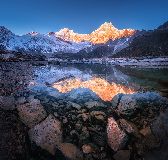日出时,照明山峰的雪山反射美丽的湖中全景景观与明亮的岩石,蓝天,池塘,石头水黎明尼泊尔喜马拉雅山脉自然图片