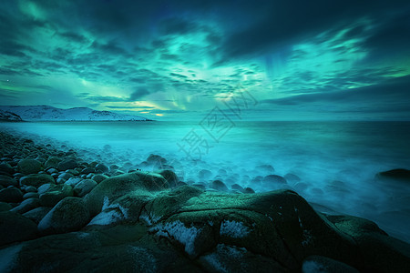 北极光岩石海滩海洋上俄罗斯泰伯卡的北极光极地灯光的星空夜间冬季景观与极光,大海与石头模糊的水,雪山图片