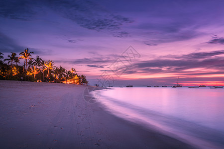 沙滩上棕榈树,夏天五颜六色的日落热带景观与海岸,模糊的水,棕榈,船游艇海洋,紫色的天空与云夜间异国他乡的非洲图片