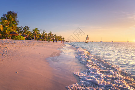 沙滩上海浪,棕榈树散步的人五颜六色的日落夏天热带景观,蓝色的海洋,棕榈,船游艇海洋,美丽的天空异国他乡的非图片
