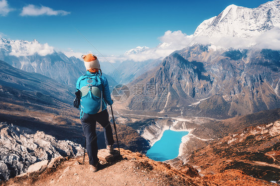 秋天山顶上背着背包的女人美丽的山云中,湖日落时蔚蓝的水风景与孤独的女孩,雪岩,天空,冰川尼泊尔秋天旅行图片