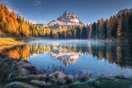 意大利白云岩,秋季日出时,湖反射着山脉景观与安托诺湖,蓝色的雾水上,树木与橙色的叶子高岩石秋天五颜六色的森林图片