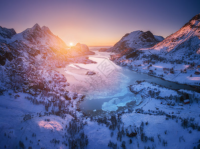 挪威洛福滕群岛日落时的雪山海洋紫色天空的空中景色冬季五颜六色的景观,积雪覆盖的岩石,霜冻的海岸,道路村庄挪威峡湾的图片