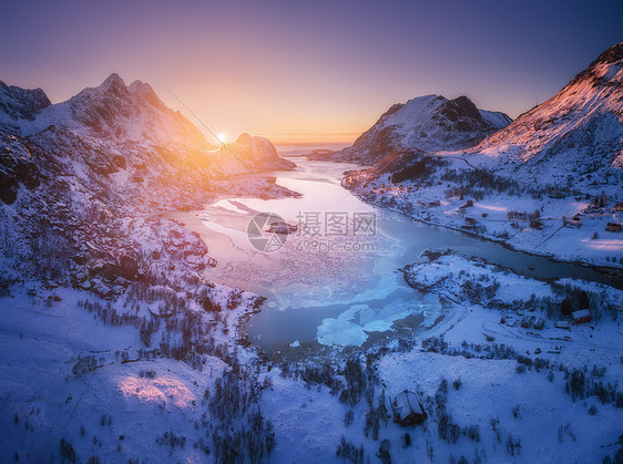 挪威洛福滕群岛日落时的雪山海洋紫色天空的空中景色冬季五颜六色的景观,积雪覆盖的岩石,霜冻的海岸,道路村庄挪威峡湾的图片