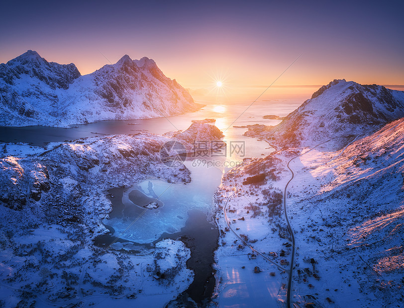 挪威洛福滕群岛日落时的雪山海洋紫色天空的空中景色冬季五颜六色的景观,积雪覆盖的岩石,霜冻的海岸,道路村庄挪威峡湾的图片