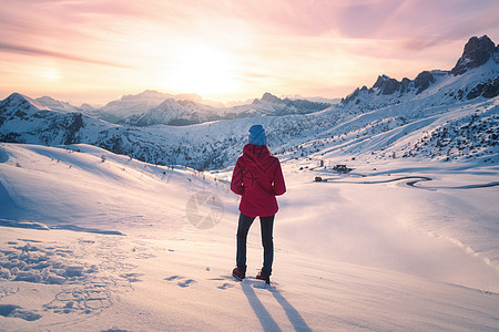 冬天日落时雪山上的轻女人风景与美丽的苗条女孩山上,雪覆盖的岩石五颜六色的天空与云彩晚上白云岩中旅行旅游业图片