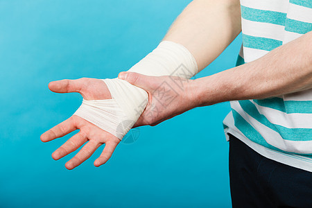 疼痛伤害的轻人握着绷带的手身体受伤的部分医学医疗保健用痛苦绷带的手的人图片