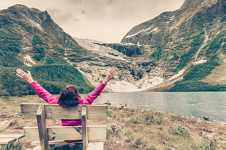 冒险徒步旅行的女人欣赏博雅布林冰川费杰兰地区,索恩达尔市索格峡丹县,挪威游览挪威自然景观的游客欣赏挪威的博雅布林冰川图片