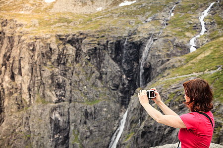 旅行,大自然中的美丽游客妇女看山,用相机特洛尔斯蒂根观赏点,挪威挪威巨人观点的旅游女图片