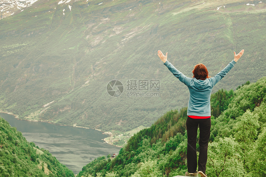 旅行游客妇女欣赏挪威的峡湾美丽的山脉景观挪威山脉峡湾的女游客图片