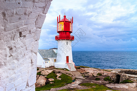 历史上红色白色灯塔岩石海岸边缘,南挪威,林德斯尼斯FYR信标挪威的林德斯尼斯灯塔背景图片