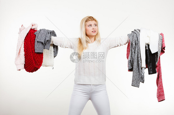 时尚,服装困境的女人着大堆暖的冬装,能决定穿什么,白色的灰色上女人着很多衣服图片