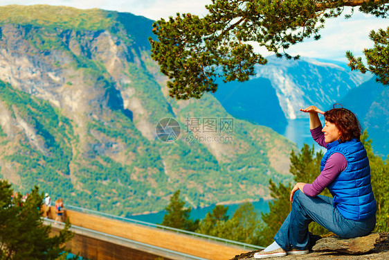 游客妇女越过Stestein瞭望台,看着挪威峡湾山脉的景色徒步旅行,旅途放松旅游景区路线极光游客享受山脉峡湾景图片