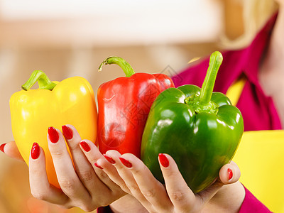 女人手钟椒美味健康的减肥蔬菜,呈现三种颜色的饮食食物着辣椒辣椒的女人图片