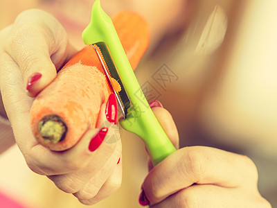 女人用食物剥皮机剥蔬菜烹饪女上菜前先准备胡萝卜图片