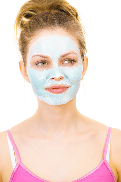 轻的女人脸上戴着绿色的泥浆具,白色的少女照顾油皮肤,净化毛孔美容治疗护肤脸上戴着绿色泥浆具的女孩图片