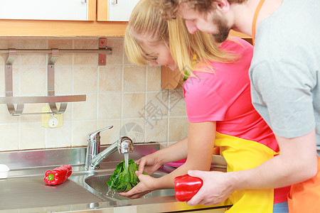 轻夫妇饭,溪水下的厨房里洗新鲜蔬菜红椒绿生菜,准备沙拉素餐图片