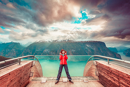 Stestein观点上的旅游女晚上欣赏极光峡湾景观,挪威的SognOg峡湾挪威Stestein观点上的游客图片