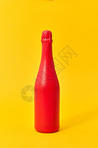 装饰彩绘红色酒瓶模拟黄色背景与最小的红色油漆喷雾模拟瓶黄色背景图片