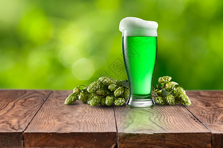 天然机啤酒花的,自然模糊的背景下,木桌上放杯新鲜的冷绿啤酒,快乐的帕特里克日用杯新鲜的绿色啤酒图片
