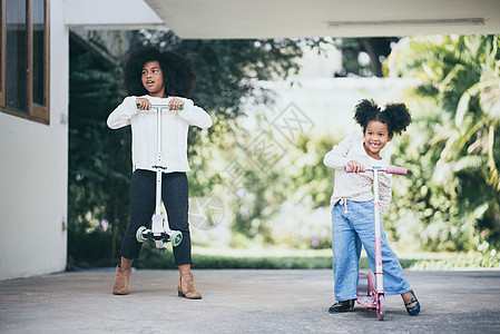 两个女孩姐妹正享受玩滑板车图片