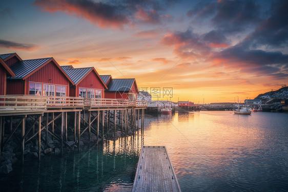 海边木桩上的红色Rorbu,小码头,冬天日出时五彩缤纷的天空挪威洛福腾群岛传统的挪威人,倒影水中,船渔村图片
