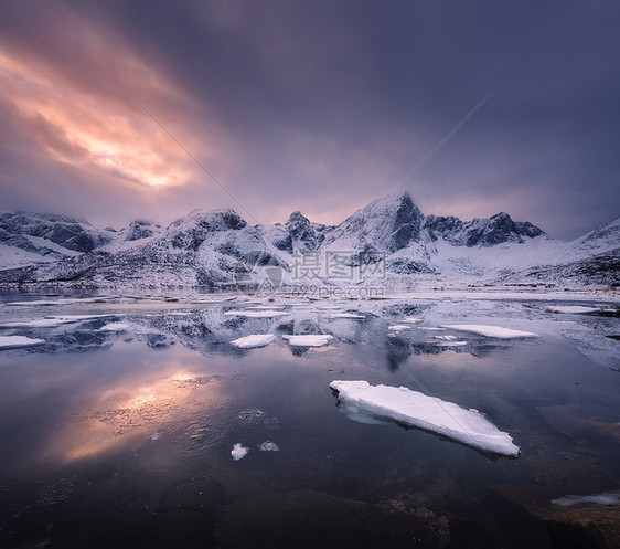 雪山,蓝色的大海霜冻的海岸,挪威洛芬岛五颜六色的日落时,水多云的天空中反射冬天的风景雪覆盖的岩石,晚上冰的峡湾图片