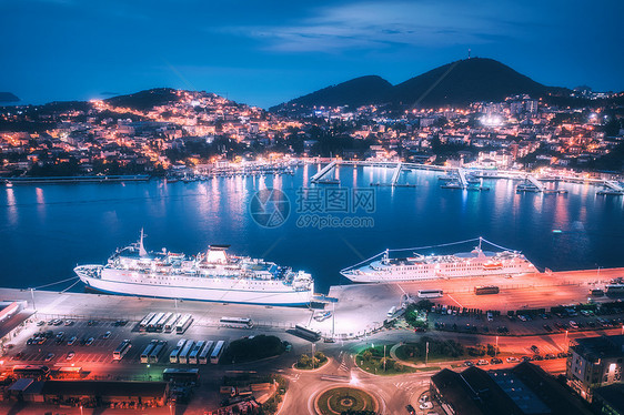 夜间游轮港口的鸟瞰图港口城市灯光建筑物山脉蓝色大海中的船只船只景观的风景豪华游轮港口的浮动轮图片